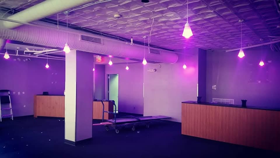 Commercial retail build-out with hanging pendant bulbs and color-changing accent lighting