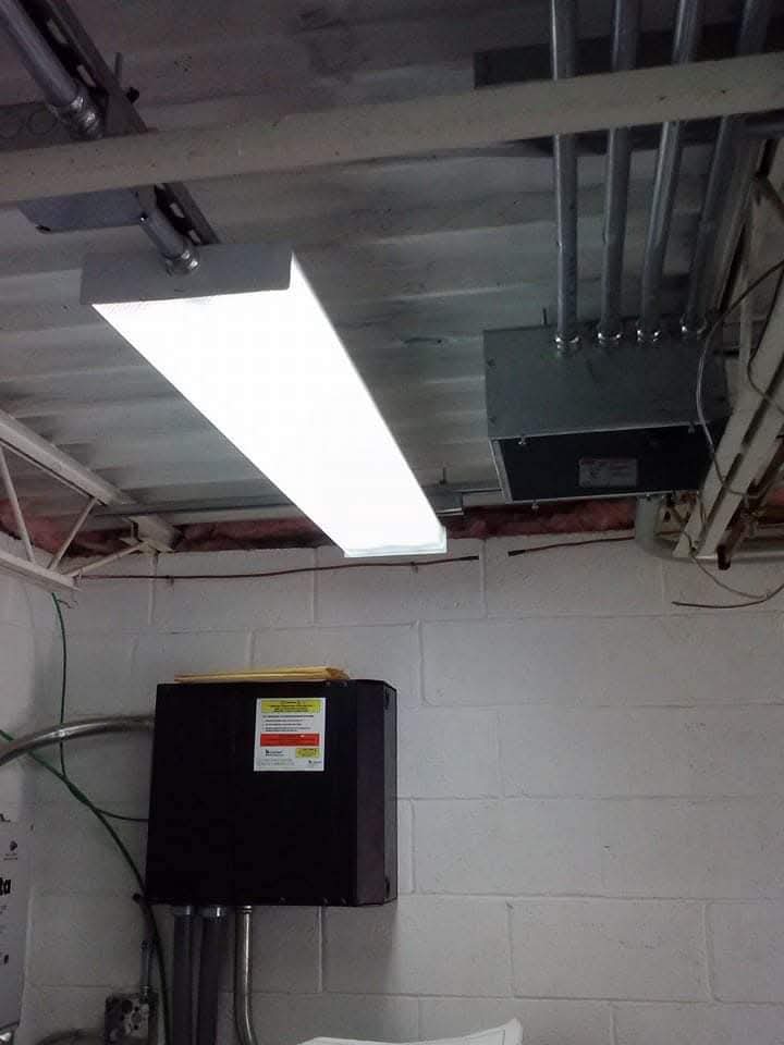 LED shop light and junction box installed on an exposed basement ceiling