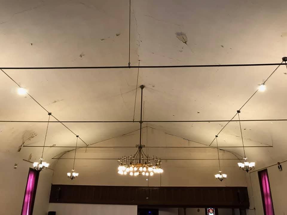 Vaulted banquet hall ceiling with a large brass chandelier and matching pendant fixtures