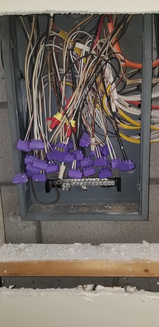 Electrical panel rough-in with labeled circuits and wire connectors before trim-out