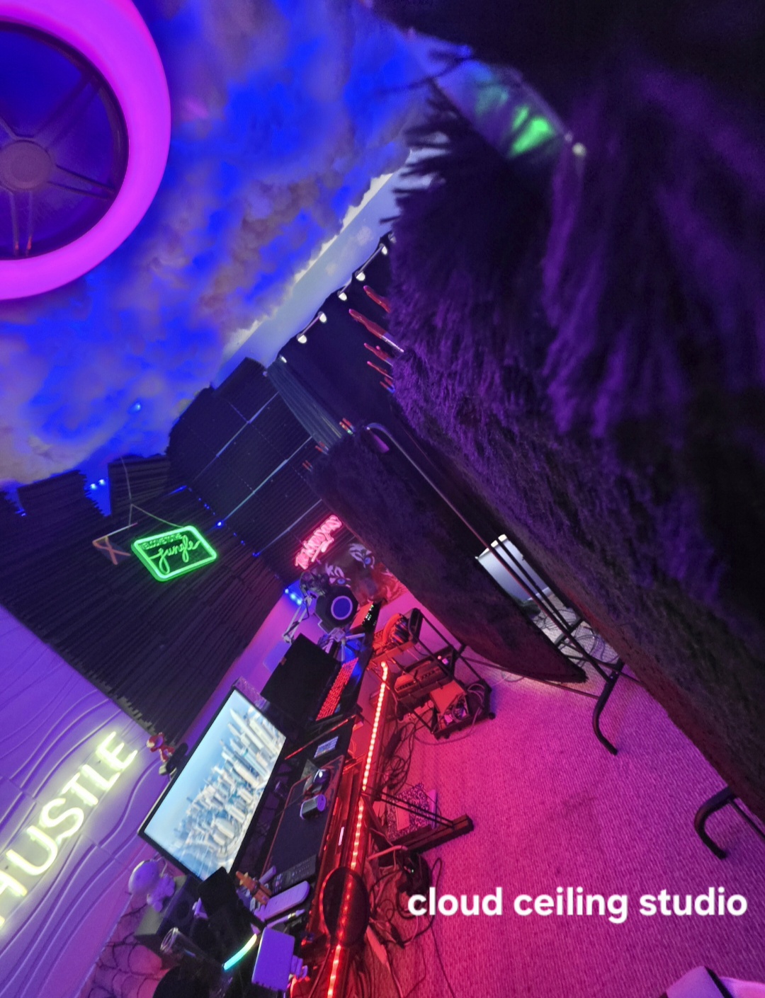 Studio room with a cloud ceiling, neon signs, and multicolor LED strip lighting