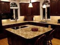 Kitchen with granite island, pendant lights, and warm under-cabinet lighting