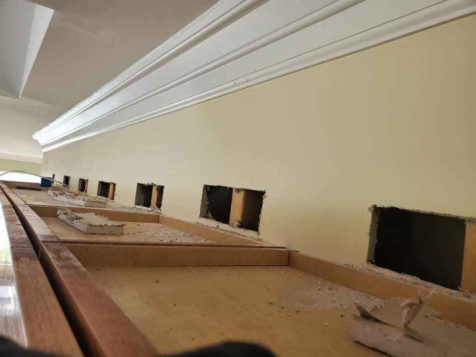 Wall openings cut in a row for sconce rough-in wiring below crown molding